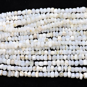 May include: A strand of white gemstone beads, each bead is a unique, irregular shape. The beads are strung on a thin wire and are ready to be used for jewelry making.