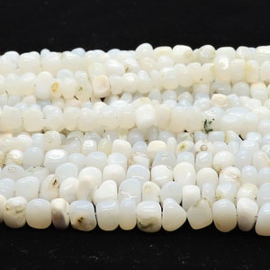 May include: A strand of white opaque gemstone beads. The beads are irregular in shape and have a slightly cloudy appearance.