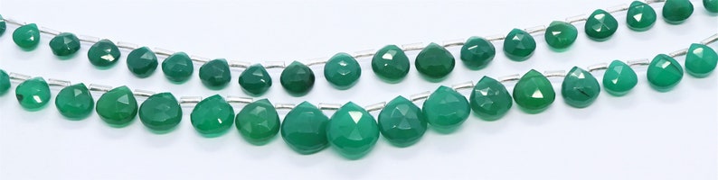 Puede incluir: Una hebra de cuentas de piedras preciosas verdes, cada cuenta est&aacute; facetada y tiene forma de l&aacute;grima. Las cuentas est&aacute;n enhebradas en un alambre de plata.