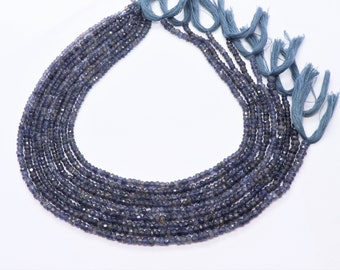 May include: A strand of blue gemstone beads, with a tassel at the end. The beads are small and round, and they are strung on a thin cord.