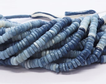 Pode incluir: Um fio de contas de opala azul e branca. As contas são pequenas e redondas, e são enfiadas em um fio branco. As contas são uma mistura de azul claro e escuro, e têm um brilho ligeiramente iridescente.