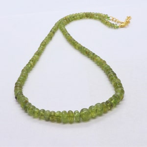 Op de afbeelding: Een groene edelsteen ketting met een gouden sluiting. De ketting is gemaakt van kleine, ronde kralen.