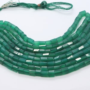 May include: A strand of green gemstone beads, each bead is a rectangular prism with slightly rounded edges. The beads are strung on a thin cord with a tassel at one end.