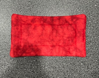 May include: Red fleece pet bed with a black border and a tie-dye pattern.