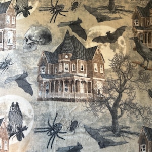 May include: A fabric print featuring a repeating pattern of brown houses, gray skulls, black spiders, bats, beetles, owls, and bare trees against a beige background. The design includes full moons and detailed illustrations of haunted-style architecture.