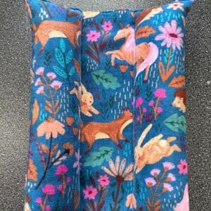 May include: A blue fabric cushion with a woodland animal print. The print features a fox, a rabbit, a deer, a unicorn, and a hedgehog. The cushion is made of soft, plush fabric and is perfect for adding a touch of whimsy to any room.