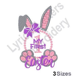 Könnte beinhalten: Stickerei mit einem Hasen mit einer lila Schleife und dem Text "My First Easter" mit der Zahl 1 in einem Kreis.