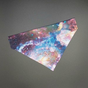 May include: A triangular bandana with a galaxy print featuring shades of blue, pink, and purple. The print resembles a nebula with stars and swirling colors.