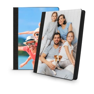 May include: Two photo album covers with black borders. The left cover features a family of three on a beach. The right cover features a family of five with a dog sitting on a sofa.