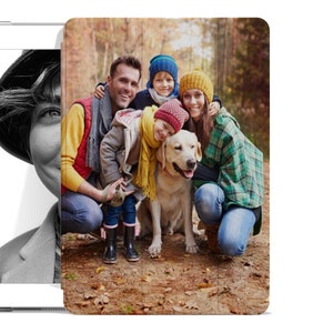 May include: A family of four and their dog pose for a photo in a wooded area. The family are wearing colourful hats and winter clothing. The dog is a golden retriever.