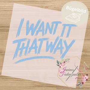 Könnte beinhalten: Ein hellblaues Bügelbild mit dem Schriftzug I WANT IT THAT WAY in Pinselstrich-Optik. Das Design enthält ein kreisförmiges Symbol mit einer Bügeleisengrafik und dem Wort Bügelbild sowie ein florales Logo mit dem Text Janines Fadenzauber.