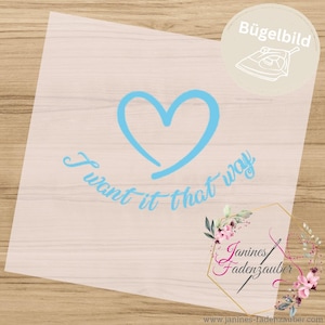 Könnte beinhalten: Ein hellblaues Bügelbild mit einem handgezeichneten Herzumriss über dem Schriftzug I want it that way in Schreibschrift. Das Design befindet sich auf einer transparenten Folie mit einem kreisförmigen Logo in der Ecke.