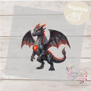 May include: An iron-on transfer featuring a stylized black dragon with geometric scales, orange glowing eyes, a bright orange heart-shaped chest emblem, and orange accents on its wings, back, and tail. The text Bügelbild is visible.