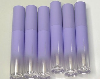 Puede incluir: Seis tubos de brillo de labios transparentes, vacíos, de color lavanda con una tapa plateada.