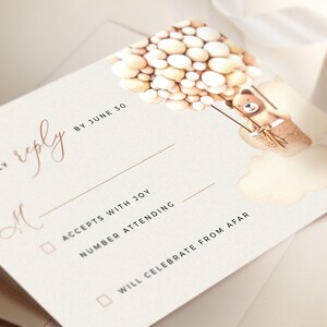 May include: A white RSVP card with a brown teddy bear holding onto a bunch of balloons. The card has the text "KINDLY reply BY JUNE 30" and a checkbox for "ACCEPTS WITH JOY" and "WILL CELEBRATE FROM AFAR".