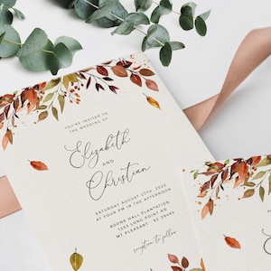 May include: Wedding invitation with a watercolor design of fall leaves in shades of orange, red, and yellow. The invitation text reads "You're invited to the wedding of Elizabeth and Christian" and includes the date, time, and location of the wedding.