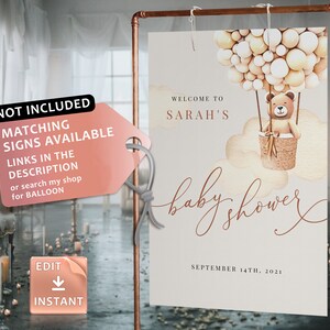 May include: A printable baby shower sign with a watercolor illustration of a teddy bear in a hot air balloon. The sign says "Welcome to Sarah's Baby Shower" and "September 14th, 2021".