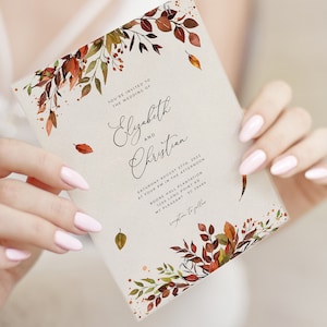 May include: A wedding invitation with a watercolor design featuring fall leaves in shades of orange, red, and green. The invitation text reads "You're invited to the wedding of Elizabeth and Christian. Saturday August 27th, 2022 at four PM in the afternoon. Boone Hall Plantation 1253 Long Point Rd Mt Pleasant SC 29464"