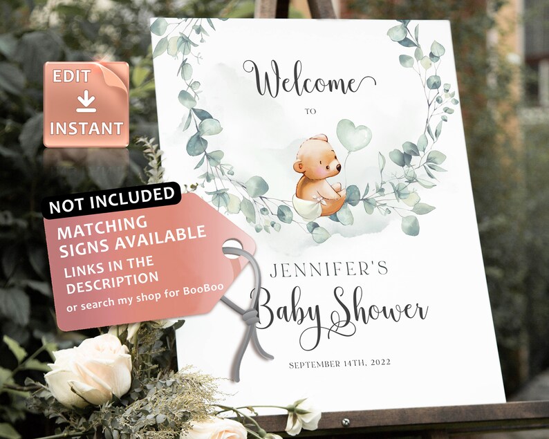 May include: Welcome to Jennifer's Baby Shower sign with a watercolor background featuring a cute teddy bear holding a heart-shaped balloon. The sign is decorated with eucalyptus leaves and has the date September 14th, 2022.