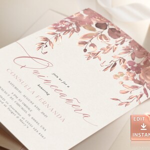 May include: A blush pink and gold Quincea&ntilde;era invitation with a floral design. The invitation reads "Join us for a Quincea&ntilde;era honoring Consuela Fernanda" and includes the date, time, and location of the event.