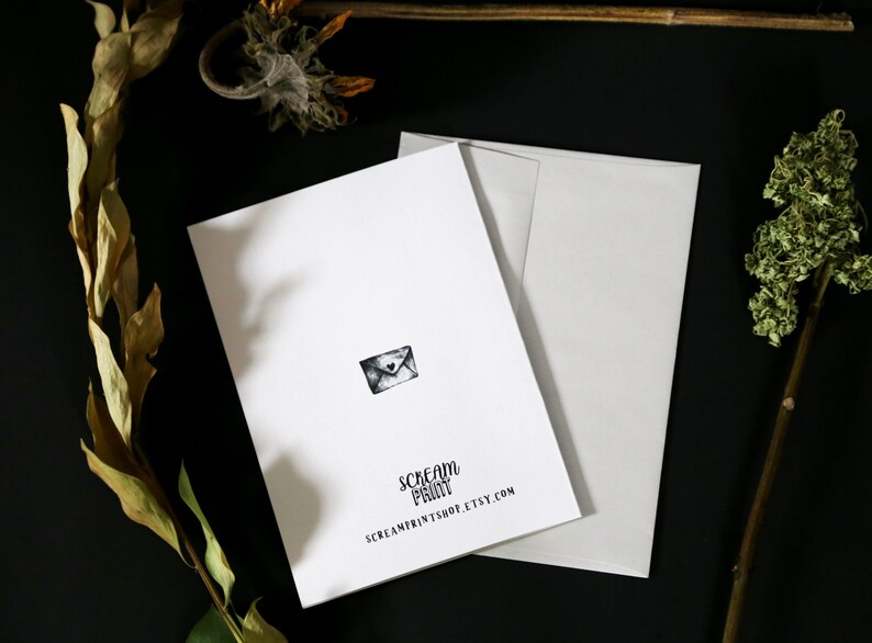 May include: A white card with a black and white illustration of an envelope with a heart on it. The card has the text "Scream Print" and "screamprintshop.etsy.com" printed on it.
