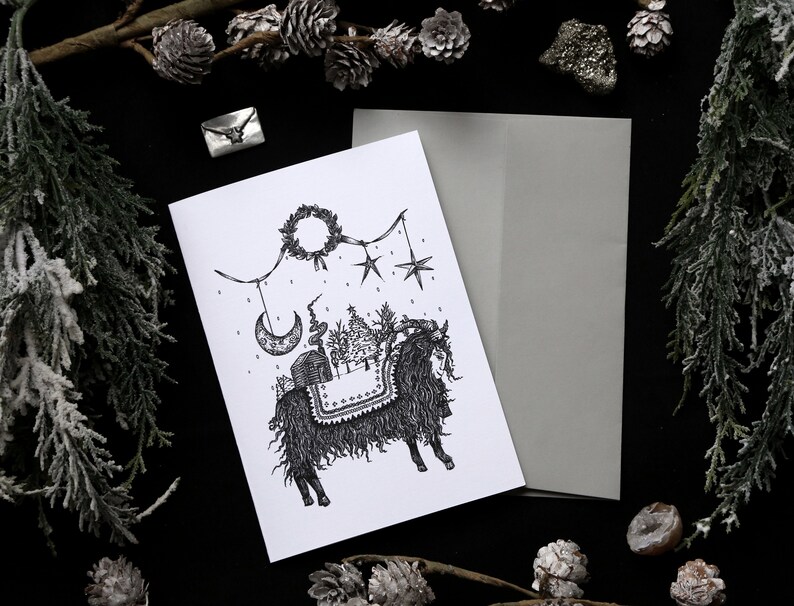 May include: A black and white illustration of a furry creature with a saddle and a wreath hanging above it. The creature is surrounded by stars and a crescent moon. The illustration is on a white card.