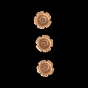 May include: Three gold-colored metal flower-shaped decorative pieces arranged vertically.
