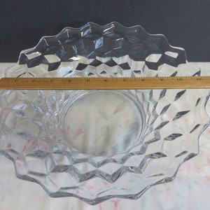 May include: A clear glass serving bowl with a diamond pattern. The bowl is 11 inches in diameter.