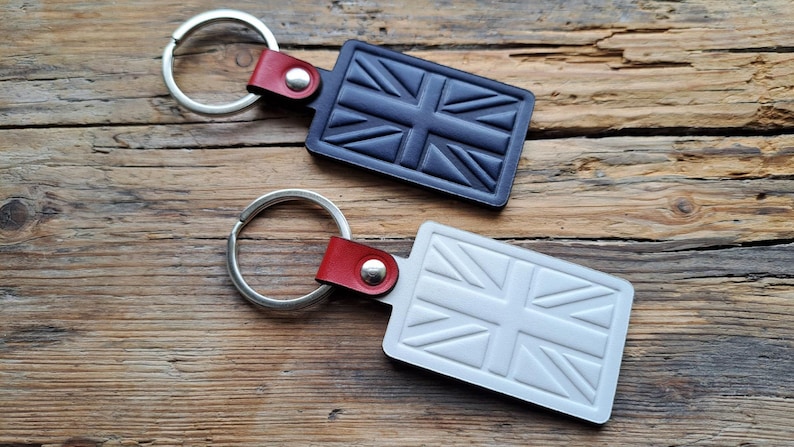 Puede incluir: Dos llaveros de cuero con un dise&ntilde;o de Union Jack. Un llavero es negro y el otro es blanco.