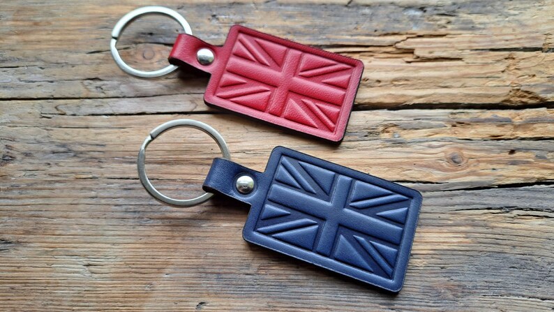 Puede incluir: Dos llaveros de cuero con un dise&ntilde;o de Union Jack. Un llavero es rojo y el otro es azul.