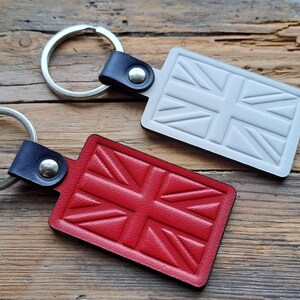 Puede incluir: Dos llaveros de cuero con un dise&ntilde;o de Union Jack. Un llavero es rojo y el otro es blanco.