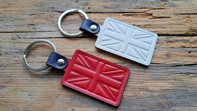 Puede incluir: Dos llaveros de cuero con un dise&ntilde;o de Union Jack. Un llavero es rojo y el otro es blanco.