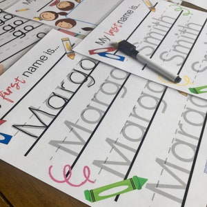 May include: A printable worksheet for practising handwriting. The worksheet has the words "My full name is", "first name is", and "My last name is" printed on it. The word "Margo" is written in cursive on the worksheet. There are also crayons and a marker on the worksheet.