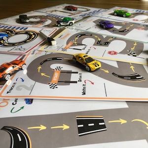 K&ouml;nnte beinhalten: Ein Satz druckbarer Arbeitsbl&auml;tter mit einer Nummer 2 Rennstrecke mit einem gelben Spielzeugauto. Die Bl&auml;tter enthalten Anweisungen zum Nachzeichnen, Schreiben und Fahren des Autos um die Strecke.