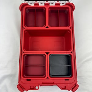 May include: A red plastic tool organizer with multiple compartments. The organizer has a clear lid and is designed for storing small tools and hardware. The interior features various sized compartments, including some with dividers, and a black tray.