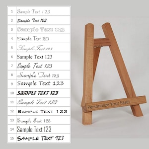 Könnte beinhalten: Ein Holzstaffelei mit weißem Hintergrund und einer Liste von Textbeispielen in verschiedenen Schriftarten und Größen. Der Text lautet "Sample Text 123" in verschiedenen Schriftarten und Größen. Die Staffelei hat ein Schild mit der Aufschrift "Personalisieren Sie Ihre Staffelei".