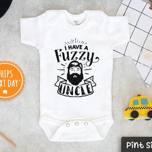 May include: White baby onesie with black text that reads "I have a Fuzzy Uncle". The text is surrounded by a black starburst. A cartoon image of a man with a beard is in the center of the text.