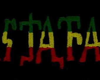 May include: Black background with the word "Rastafari" in green, yellow, and red, the colors of the Rastafarian flag. The letters appear to be textured, with a slightly distressed look.