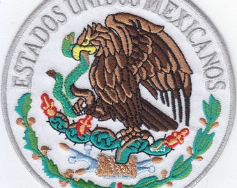 May include: A white embroidered patch with the Mexican coat of arms. The coat of arms features a golden eagle perched on a cactus with a snake in its beak. The text "ESTADOS UNIDOS MEXICANOS" is written in a circle around the eagle.