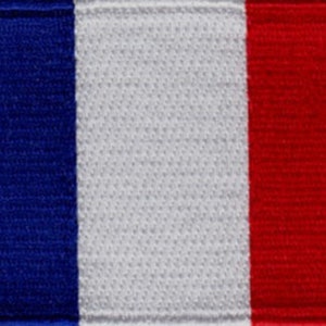 May include: A blue, white, and red fabric patch with the colors arranged vertically. The patch is a representation of the French flag.