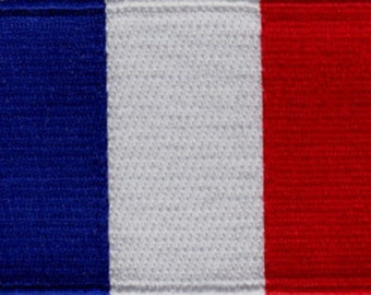 May include: A blue, white, and red fabric patch with the colors arranged vertically. The patch is a representation of the French flag.
