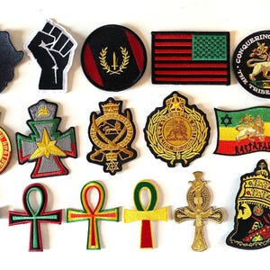 Puede incluir: Una colección de 15 parches bordados con varios símbolos y diseños relacionados con la cultura rastafari, incluyendo el León de Judá, el Ankh y la bandera rastafari. Los parches son de varios colores, incluyendo rojo, verde, amarillo y negro.