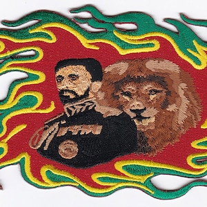 Può includere: Toppa ricamata raffigurante un uomo e un leone, incorniciati da fiamme rosse, verdi e gialle. La toppa è progettata per essere applicata su abbigliamento o accessori, mostrando cuciture dettagliate.