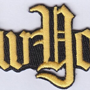 May include: Gold embroidered patch with the word "New York" in a stylized font.