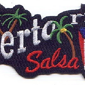 May include: Embroidered patch with the text "Puerto Rico Salsa" in white and red lettering on a black background. Two palm trees are on the left side of the patch, and a stylized image of the Puerto Rican flag is on the right side.