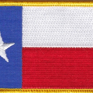 May include: A blue, white, and red embroidered patch with a white star in the blue section. The patch is surrounded by a gold border.