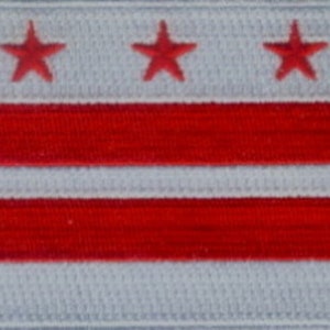 May include: A white flag with three red stars and three red horizontal stripes. The flag is a representation of the District of Columbia.