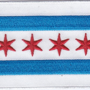 May include: A white patch with a blue and white striped design and four red six-pointed stars. The stars are arranged in a row in the center of the patch.