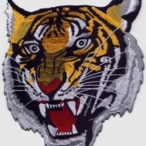 May include: A close-up of an embroidered iron-on patch featuring a snarling tiger's head with yellow, black, white, and red details. The patch measures 9 inches by 7.75 inches.