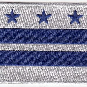 May include: A white embroidered patch with three blue stars and three blue stripes. The patch is a representation of the flag of Washington, D.C.